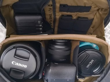 Wroclaw, Polonya - 7 Eylül 2024: Kamera gövdesi, çoklu lensler ve gerekli fotoğraf ekipmanlarıyla dolu iyi organize edilmiş kamera çantası, her türlü çekim için hazır.