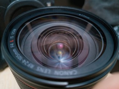 Wroclaw, Polonya - 9 Eylül 2024: Canon RF 24-105mm 'lik F / 4' ün ön unsurunun detaylı yakın plan görüntüsü, karmaşık optik tasarımı ve kaplamalarını gösteren USM aynasız kamera lensidir.