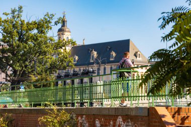 Wroclaw, Polonya - 20 Eylül 2024: Güneşli bir günde Wroclaw Üniversitesi 'nin tarihi binasının önünde elinde akıllı telefonla duran adam