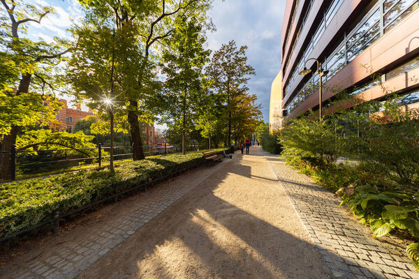 Вроцлав, Польша - 29 сентября 2024 года: Солнечный путь между зданием Национального музыкального форума и историческим рвом во Вроцлаве, где люди наслаждаются осенним днем