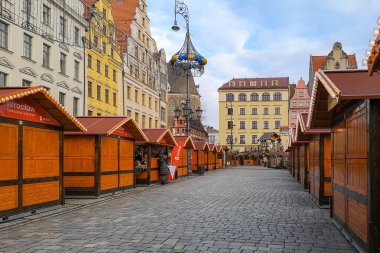 Wroclaw, Polonya - 30 Kasım 2024: Noel pazarı tezgahları ve renkli binalar ve kış şehir merkezinde tatil ağacı bulunan tarihi kasaba meydanındaki şenlikli süslemeler
