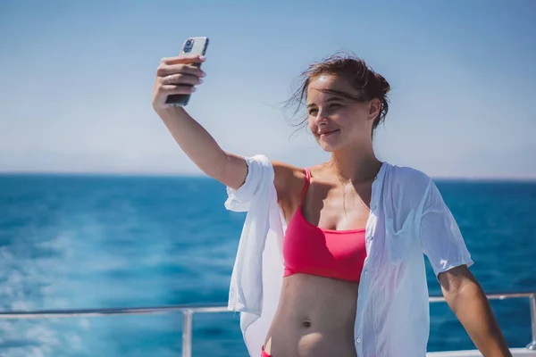 Hermosa chica toma una selfie en el mar — Foto de Stock