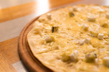 Dört peynirli pizza. Gri arka planda dört çeşit peynirle doldurulmuş pizza.