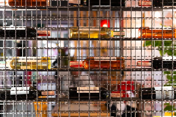 Stylish metal shelving in a cafe with bottles of wine. Abstraction in interiors