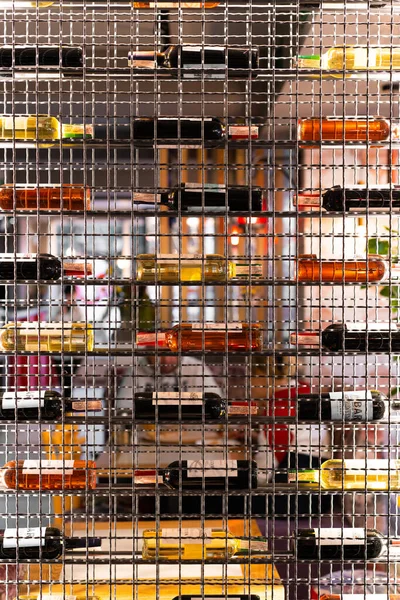 Stylish metal shelving in a cafe with bottles of wine. Abstraction in interiors