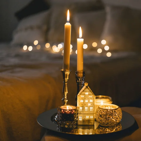 Burning candles in living room. Seasonal autumn-winter concept of a cozy home