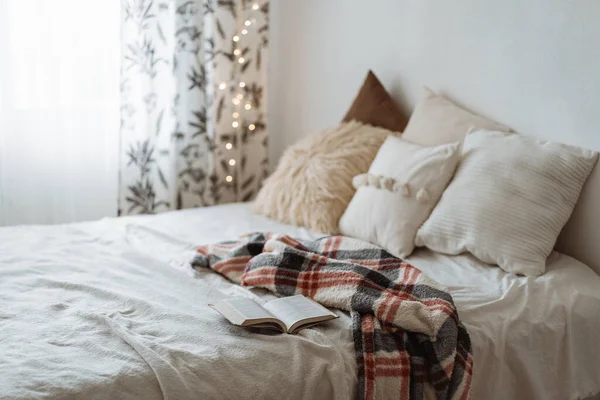 Schlafzimmer im modernen Stil mit Kissen auf dem Bett und offenem Buch — Stockfoto