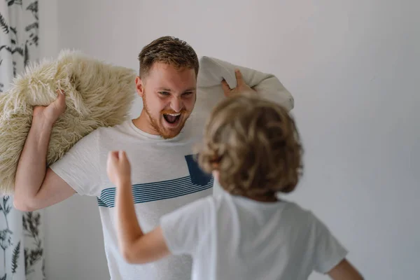 Pai e seu filho estão brincando e abraçando em casa. — Fotografia de Stock