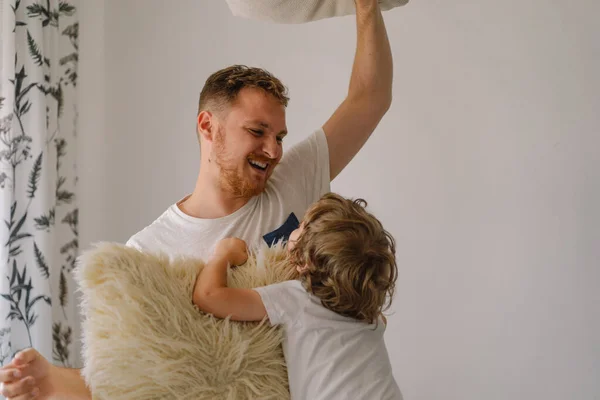 Pai e seu filho estão brincando e abraçando em casa. — Fotografia de Stock