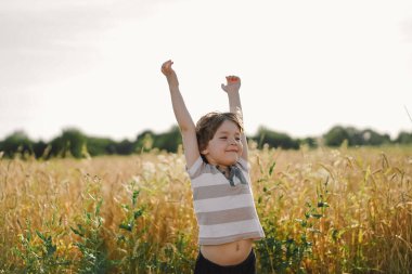 Küçük çocuk gözlerini kapadı ve ellerini havaya kaldırdı.