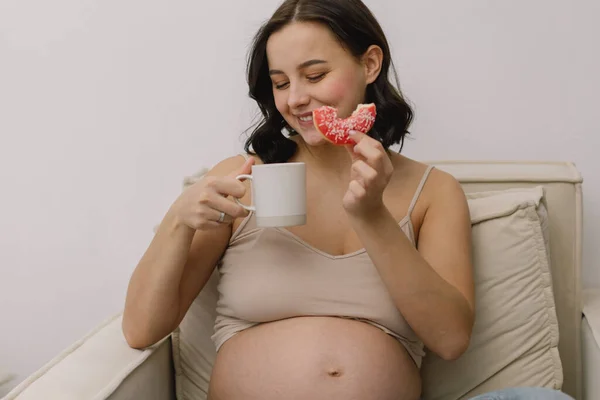 Embarazo y nutrición. Mujer embarazada disfrutando de donas y té. — Foto de Stock