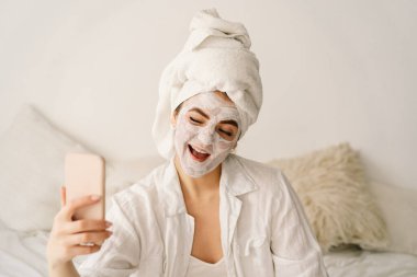 Yüz maskesi takan ve cep telefonu kullanan güzel bir kadın. Yaşam biçimi