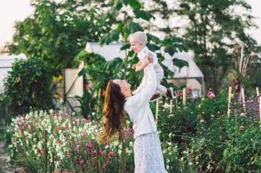 Bir serada çiçeklerle oynayan bir kadın. Anneler Günün kutlu olsun.