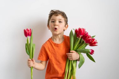 Lale çiçekli neşeli mutlu çocuk. Beyaz arka planda gülümseyen küçük çocuk. Anneler Günü, 8 Mart, Uluslararası Kadınlar Günü konsepti