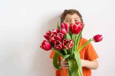 Lale çiçekli neşeli mutlu çocuk. Beyaz arka planda gülümseyen küçük çocuk. Anneler Günü, 8 Mart, Uluslararası Kadınlar Günü konsepti