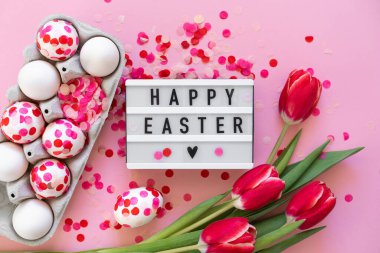 Mutlu Paskalyalar. Kağıt konfeti ve lalelerle süslenmiş Paskalya yumurtaları.