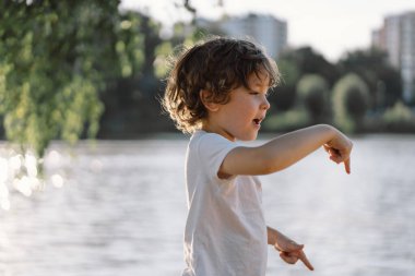 Nehir kenarındaki doğada oynayan sevimli bir çocuğun portresi..