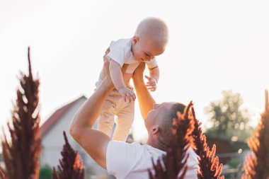 Baba ve oğlu dışarıda oynayıp sarılıyorlar. Babalar Günü kavramı. Mutlu sevgi dolu aile.