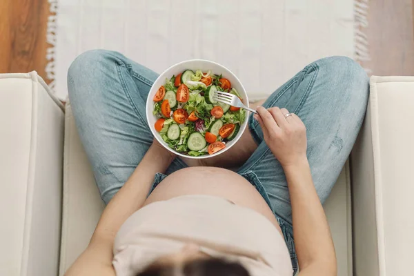 Pregnancy and healthy organic nutrition. Pregnant woman enjoying fresh vegetable salad.