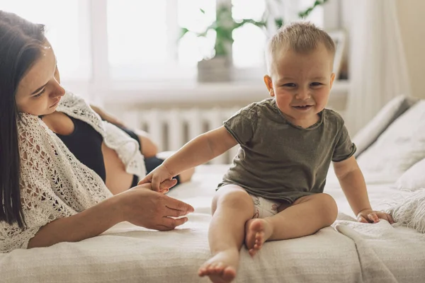 Young woman with her first child during second pregnancy. Motherhood and parenting concept. Toddler boy and mom. Happy family expecting for baby.