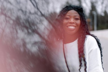 Neşeli siyah tenli kızın resmi. Şehir parkında yürüyen afro kız. Yaşam biçimi