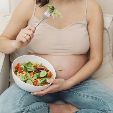 Hamilelik ve sağlıklı organik beslenme. Hamile kadın taze sebze salatasından hoşlanıyor. Beklenti ve sağlık kavramı.