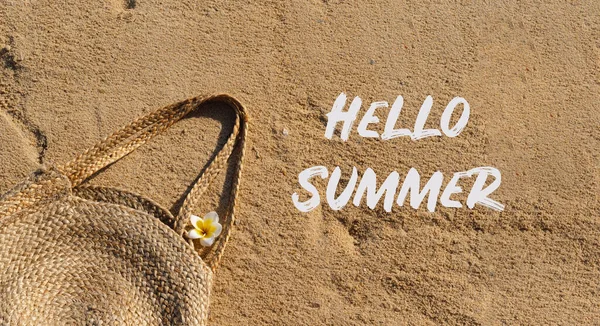 Hello Summer. Straw bag on sand. Summer beach background. Summer time. Holiday by the sea. Vacation by the ocean background.