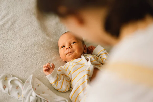 Mamá vestidos lindo bebé recién nacido niño en un mono. — Foto de Stock