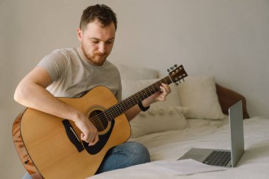 Adam online derste akustik gitar çalıyor. Hobi. Müzisyen..