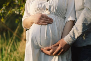 Bahar bahçesinde sarılan genç ve güzel bir çift. Hamilelik kavramı