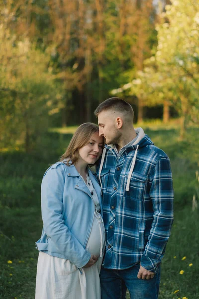 Bahar bahçesinde sarılan genç ve güzel bir çift. Hamilelik kavramı