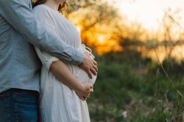 Bahar bahçesinde sarılan genç ve güzel bir çift. Hamilelik kavramı