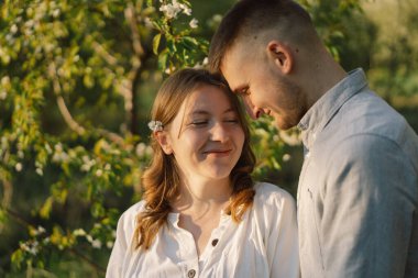 Bahar bahçesinde sarılan genç ve güzel bir çift. Hamilelik kavramı