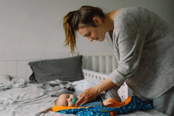 Mama Ubiera Uroczego Chłopczyka Kombinezon Szczęśliwa Młoda Matka Bawiąca Się — Zdjęcie stockowe