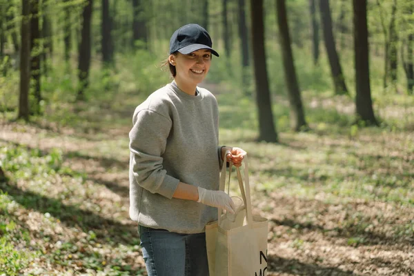 Relawan wanita yang dibersihkan di hutan. Wanita mengumpulkan plastik. — Stok Foto