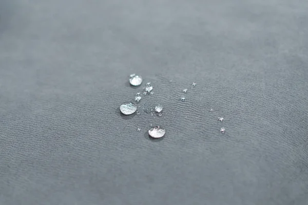 Water drops on waterproof textile material - short depth of field. Waterproof fabric on sofa