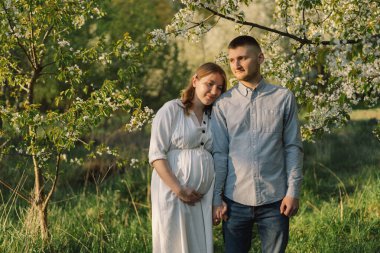 Bahar bahçesinde sarılan genç ve güzel bir çift.