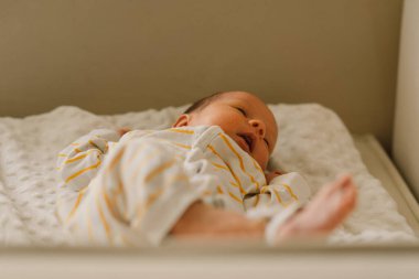 Beşikteki tatlı, duygusal, yeni doğmuş erkek bebek. Bebek eşyaları paketleme şablonu. Sağlıklı çocuk, hastane kavramı ve mutlu annelik. Bebek bebek..