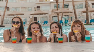 Bir grup güzel genç bayan havuzda dinleniyor. Arkadaşlar bir yaz günü havuzda dinlenir ve gülerler.