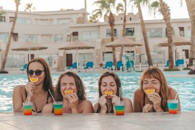 Bir grup güzel genç bayan havuzda dinleniyor. Arkadaşlar bir yaz günü havuzda dinlenir ve gülerler.