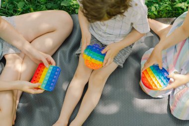 Çocuklar yeni moda pop it oyuncağıyla oynuyor. Kaliteli motor becerilerin geliştirilmesi, kabarcık kıpırdatma duyusal oyuncak yıkanabilir ve yeniden kullanılabilir silikon stres giderici oyuncak.