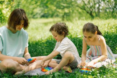 Çocuklar yeni moda pop it oyuncağıyla oynuyor. Kaliteli motor becerilerin geliştirilmesi, kabarcık kıpırdatma duyusal oyuncak yıkanabilir ve yeniden kullanılabilir silikon stres giderici oyuncak.