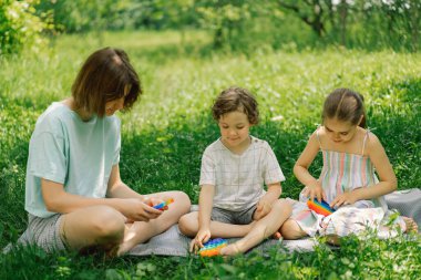 Çocuklar yeni moda pop it oyuncağıyla oynuyor. Kaliteli motor becerilerin geliştirilmesi, kabarcık kıpırdatma duyusal oyuncak yıkanabilir ve yeniden kullanılabilir silikon stres giderici oyuncak.