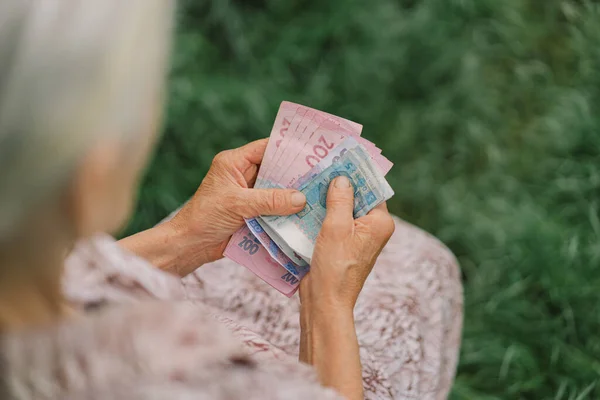 Endişeli yaşlı kadın Ukrayna parası sayıyor, Hryvnia. Yaşlılık, yoksulluk, kemer sıkma kavramı.