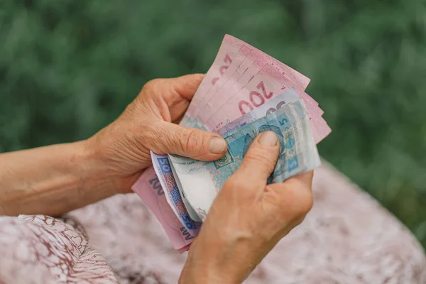 Endişeli yaşlı kadın Ukrayna parası sayıyor, Hryvnia. Yaşlılık, yoksulluk, kemer sıkma kavramı.