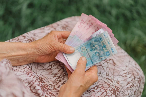 Endişeli yaşlı kadın Ukrayna parası sayıyor, Hryvnia. Yaşlılık, yoksulluk, kemer sıkma kavramı.
