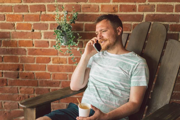 Young man laughs and talking on the phone.