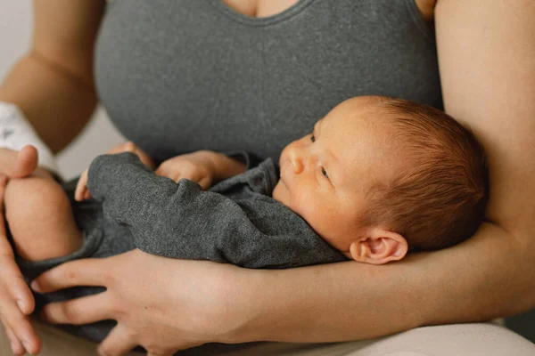 La madre sostiene y abraza a su hijo recién nacido en casa. Feliz bebé y mamá. — Foto de Stock