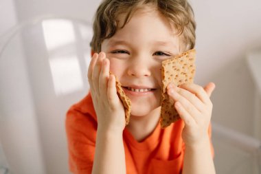 Sevimli küçük çocuk gevrek yiyor. Sağlıklı yaşam tarzı ve beslenme konsepti.