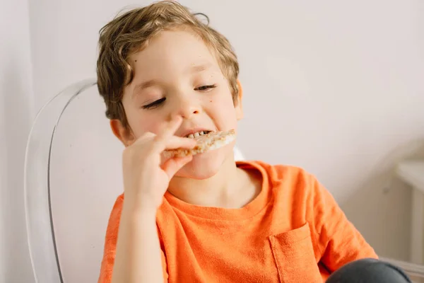 Anak kecil yang lucu makan roti renyah. Gaya hidup sehat dan konsep gizi. — Stok Foto